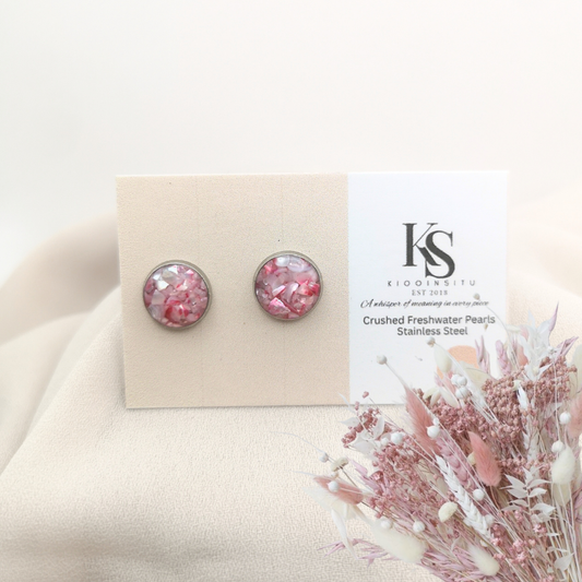Handmade with care, these 10 mm stainless steel studs feature crushed freshwater pearls in luminous blush tones, sealed beneath a clear, glass-like resin that enhances their natural glow.