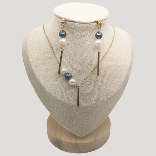 Necklace with pearls and gold bars on a mannequin bust against a light gray background
