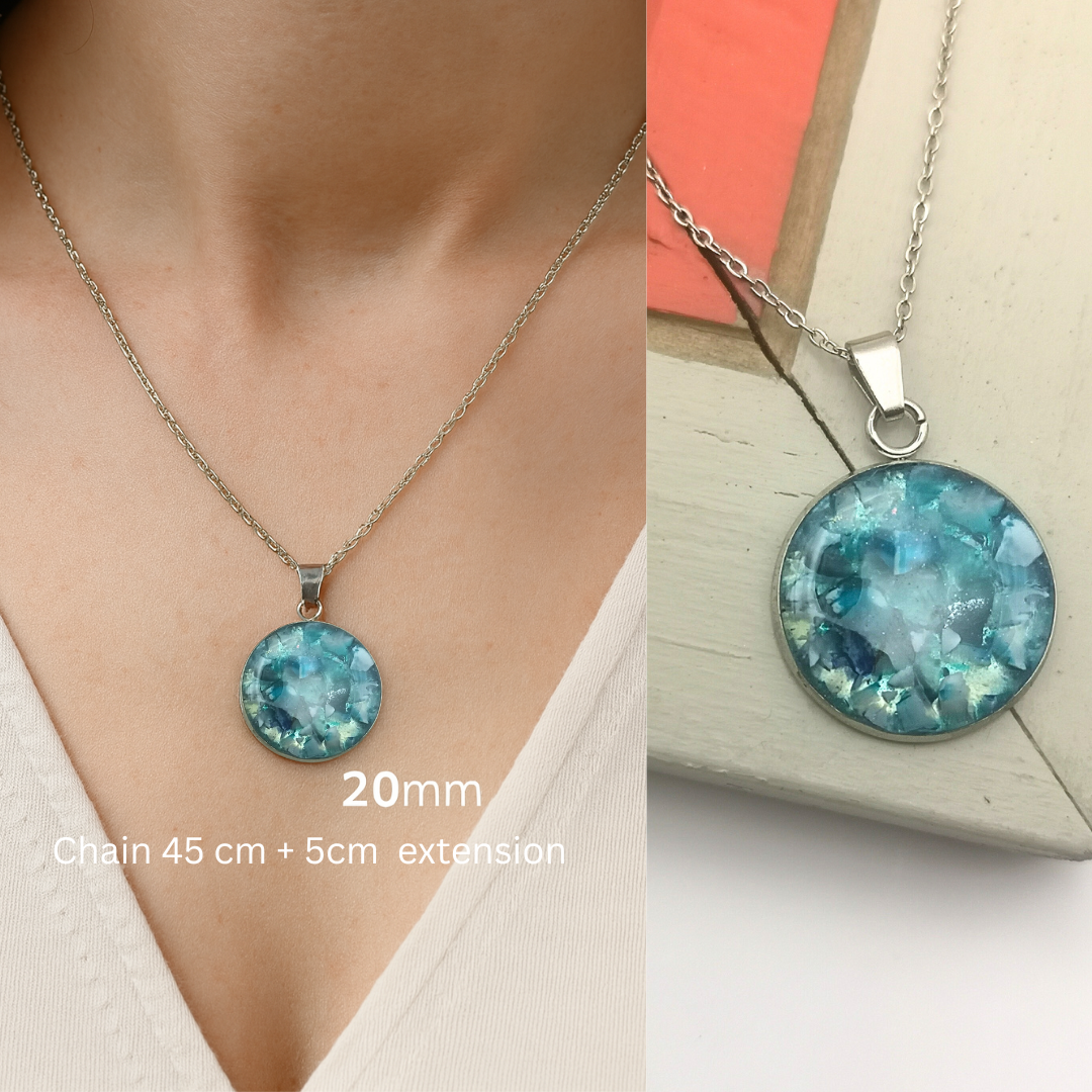 Necklace with a blue pendant worn and on a surface