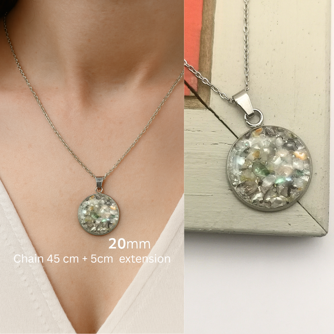Necklace with a round pendant on a person's neck and on a wooden surface.
