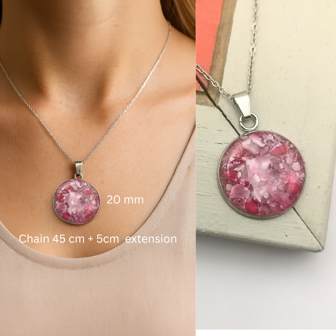 Pink pendant necklace on a person's neck and on a box