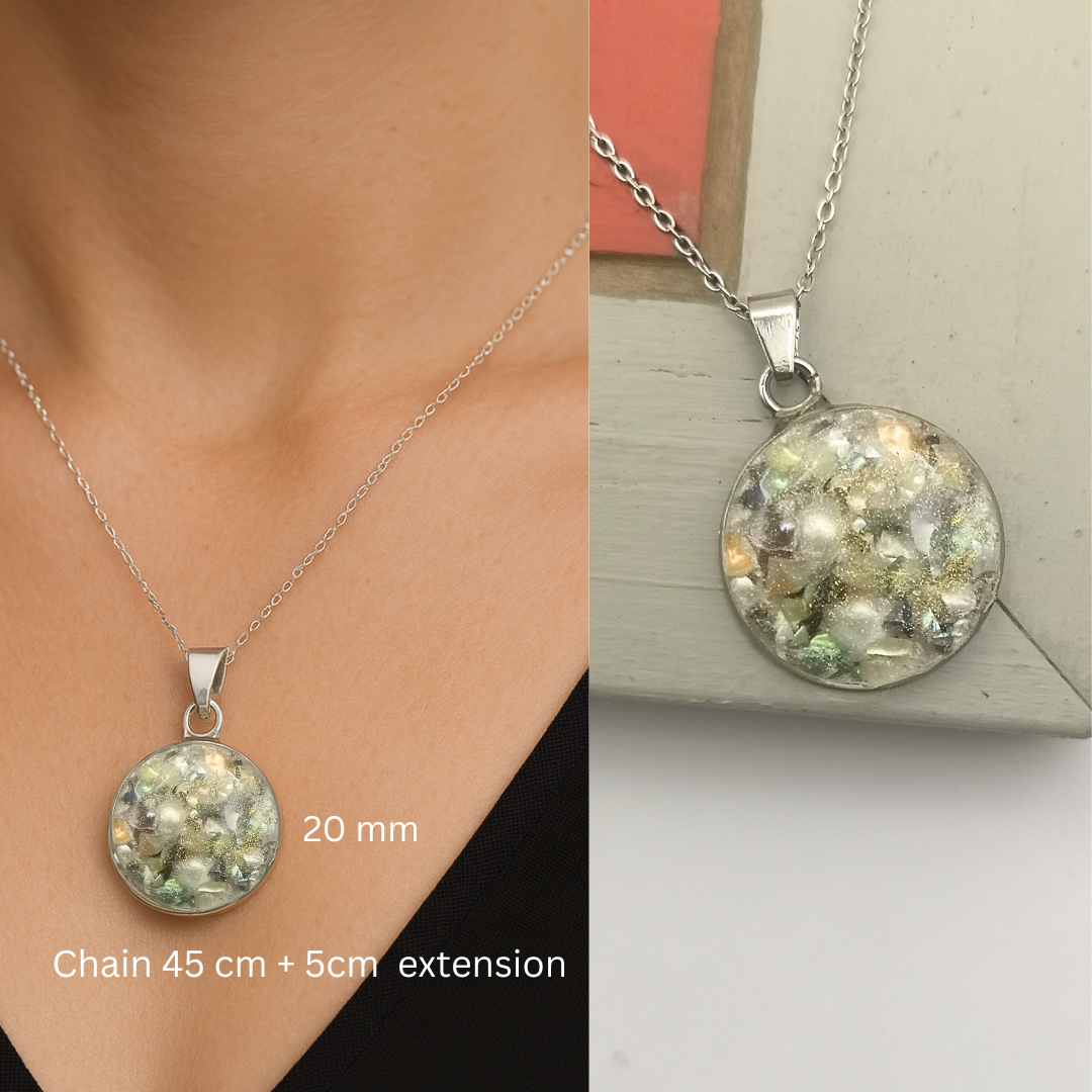 Silver necklace with a round pendant on a neutral background