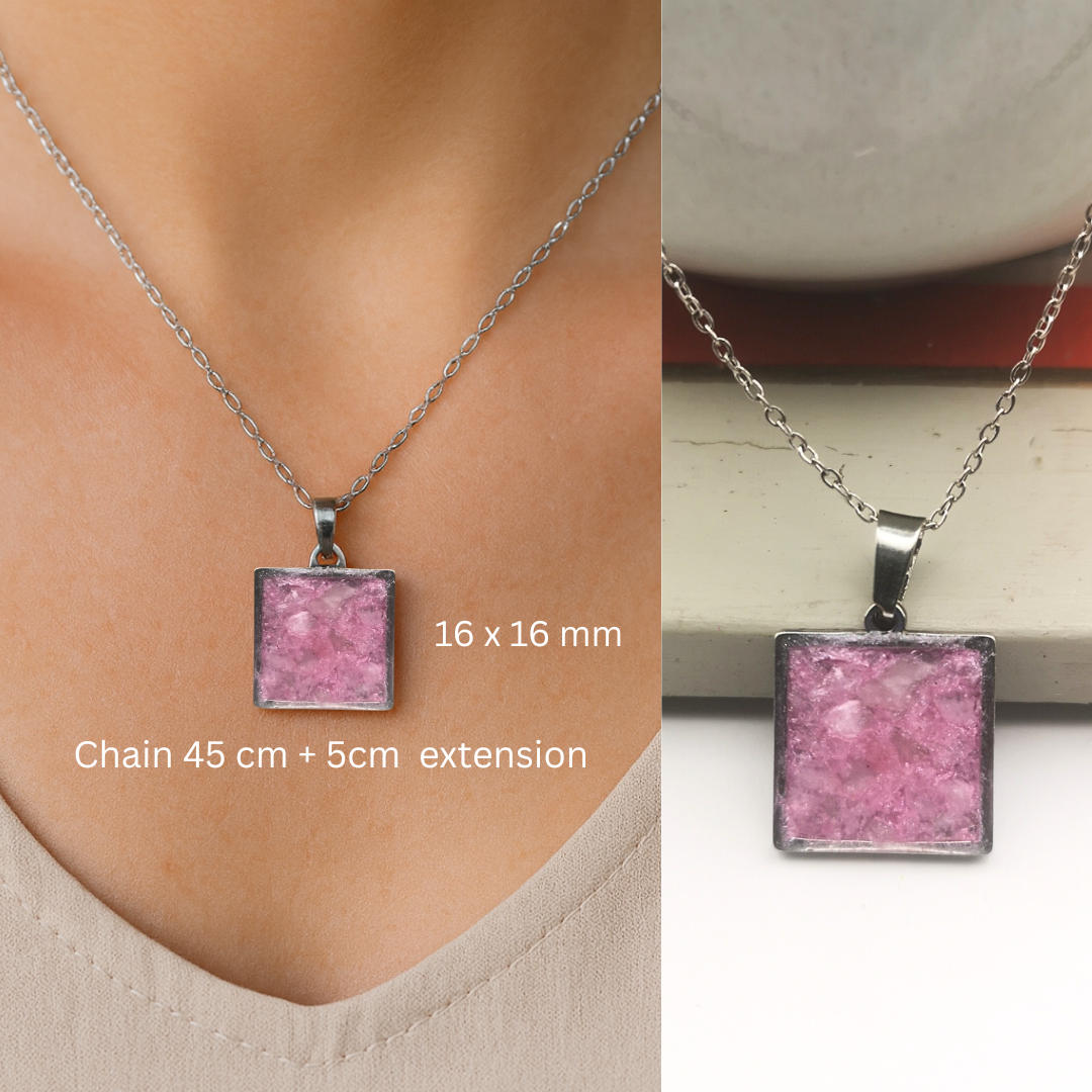 Necklace with pink square pendant on a person's neck and on a surface.