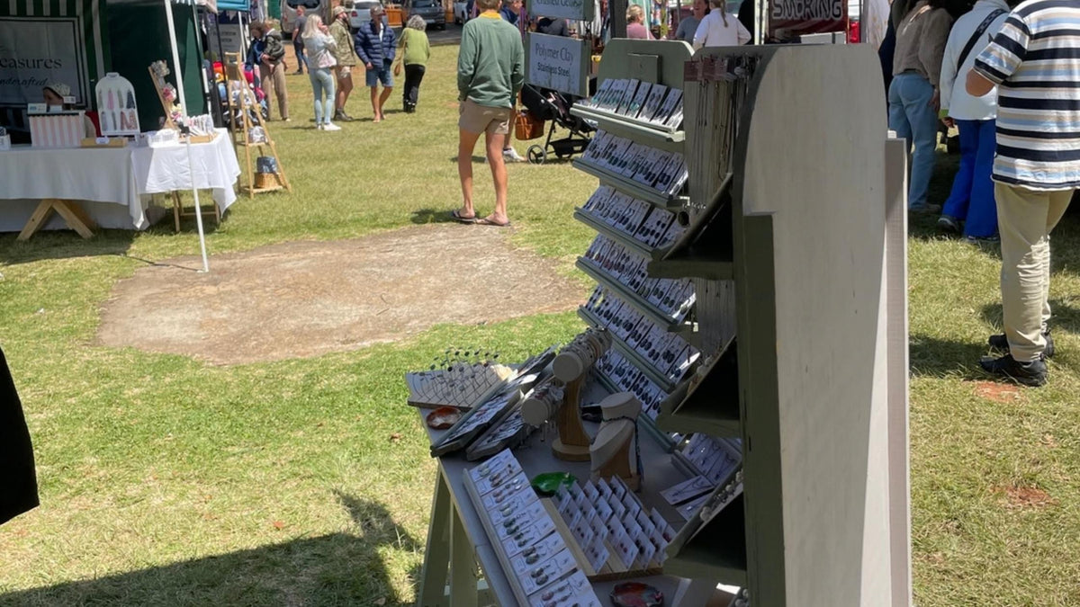 Kiooinsitu’s handmade jewellery display at Dullstroom market, with visitors browsing outdoor stalls on a sunny day