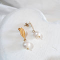 White freshwater pearl drops beneath gold-tone leaf-shaped ear studs with butterfly backs.