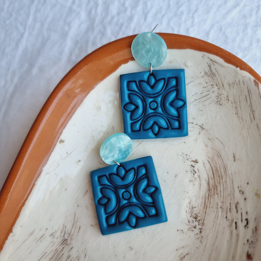 Handcrafted for a distinctive and stylish look. These eye-catching earrings feature vibrant Teal blue-colored polymer clay embossed squares