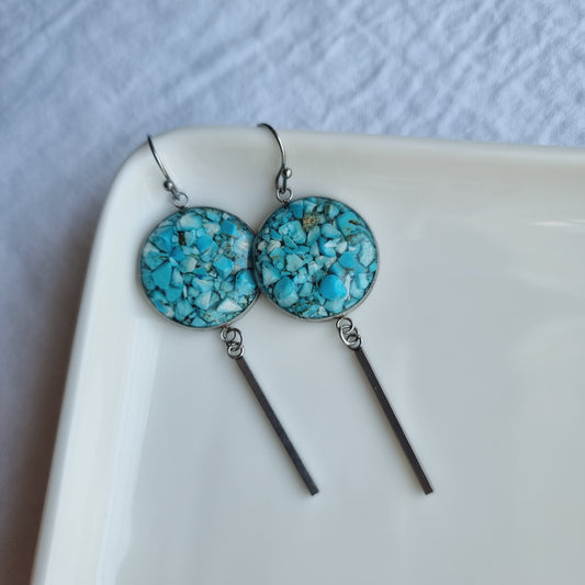 Experience the raw beauty of these handmade Turquoise Drop Earrings. The 20mm stainless steel rounds are set with raw turquoise, creating a captivating contrast