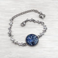  Crushed Blue Agate Bracelet features a 16mm stainless steel bezel filled with natural blue agate and sealed with a glass-like resin. 