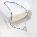 This handmade necklace brings together a white square baroque freshwater pearl, soft blue glass beads and white ceramic beads with blue stripes