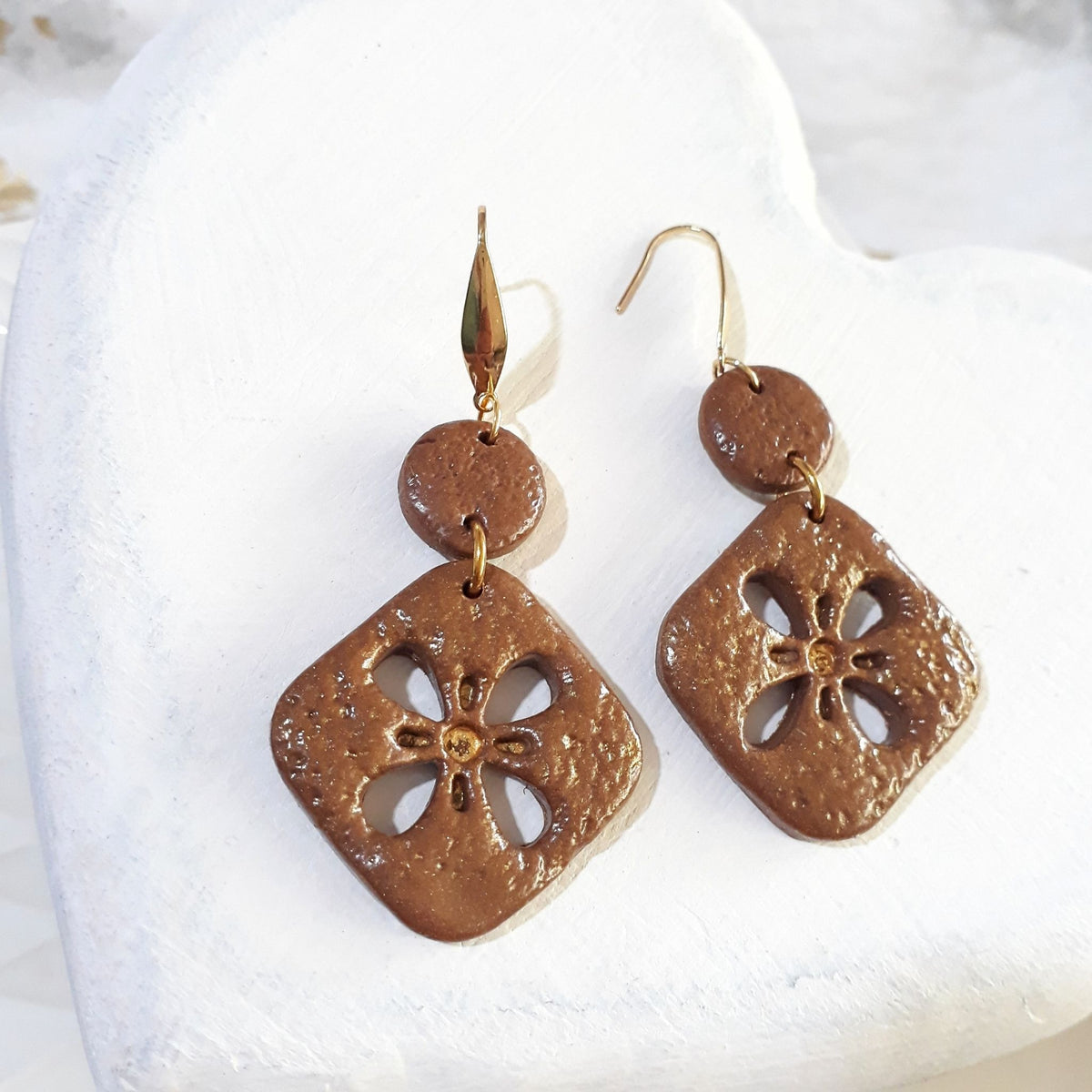 Caramel-brown textured polymer clay earrings with rounded diamond floral cutout drops, small round connectors and gold-tone elegant hooks.