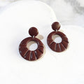 Glossy dark-brown polymer clay earrings with round stud tops and open-circle drops featuring radiating grooves.