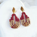 Handmade dark maroon and gold Art Deco arch polymer clay earrings - flat lay product view