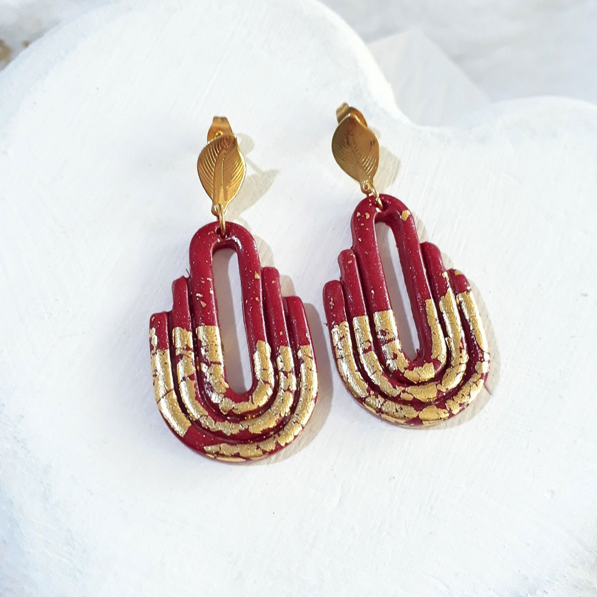 Handmade dark maroon and gold Art Deco arch polymer clay earrings - flat lay product view