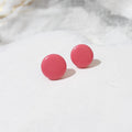 Pair of dark pink round polymer clay stud earrings with smooth glossy surfaces.