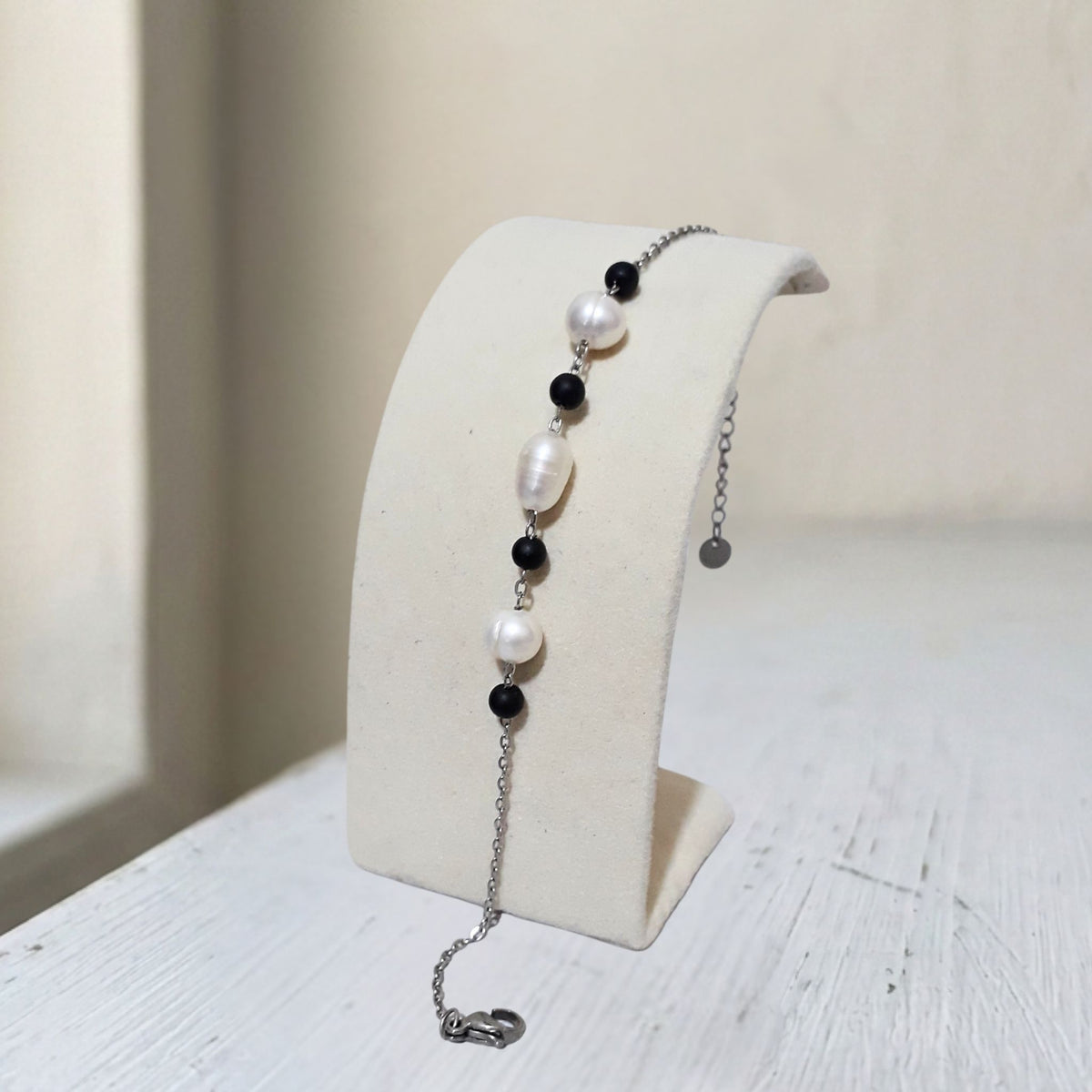 Handcrafted with stainless steel, this bracelet features natural freshwater pearls (7mm and 4mm) paired with sleek black onyx beads - Kiooinsitu