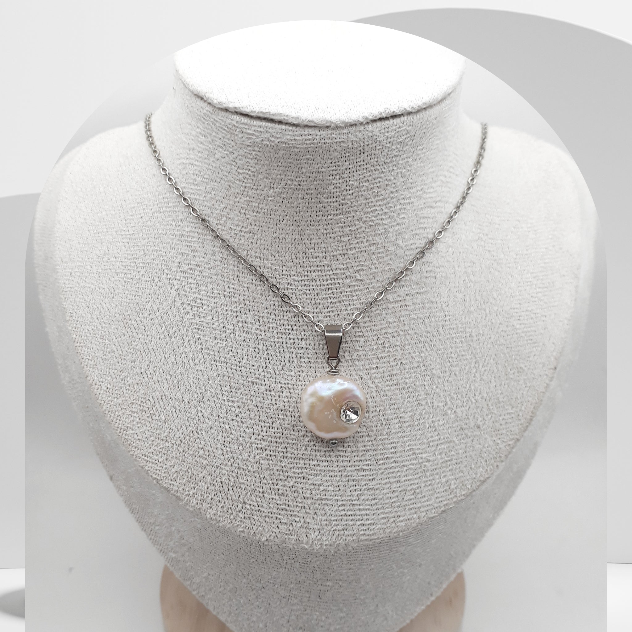 Coin Pearl necklace on a mannequin bust against a white background