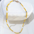 This handmade necklace pairs seven white freshwater rice pearls with yellow glass beads and small blue-and-white ceramic beads