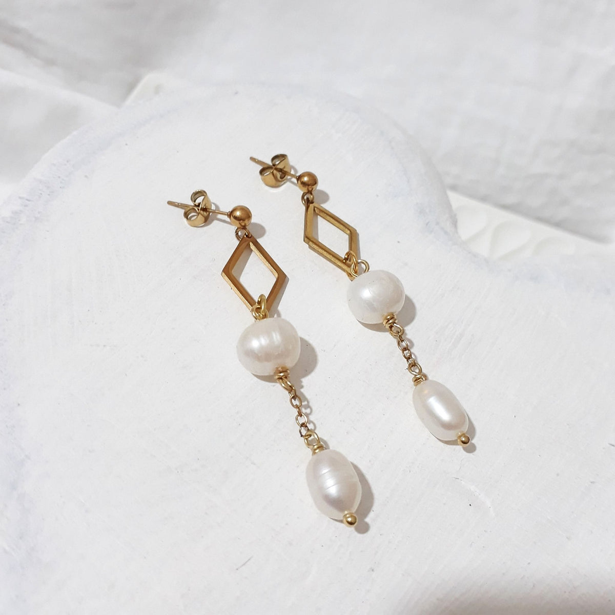 Gold-tone ball stud earrings with open diamond-shaped links, off-round white freshwater pearls and oval pearl chain drops.