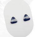 Pair of blue and white triangular earrings on a white background