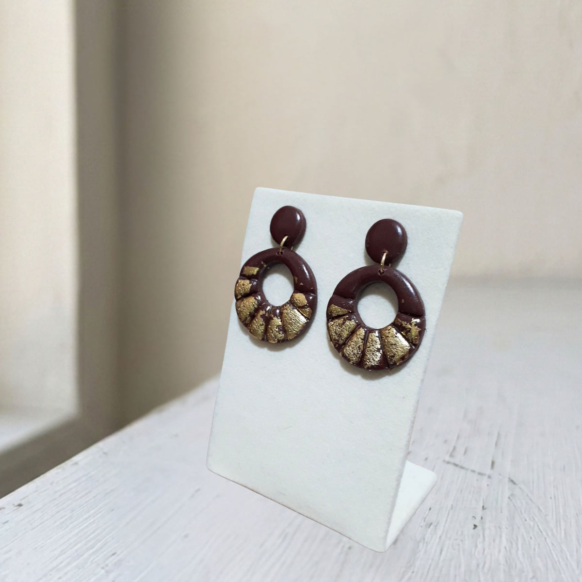 Handmade dark brown and gold scallop hoop polymer clay earrings on white display stand