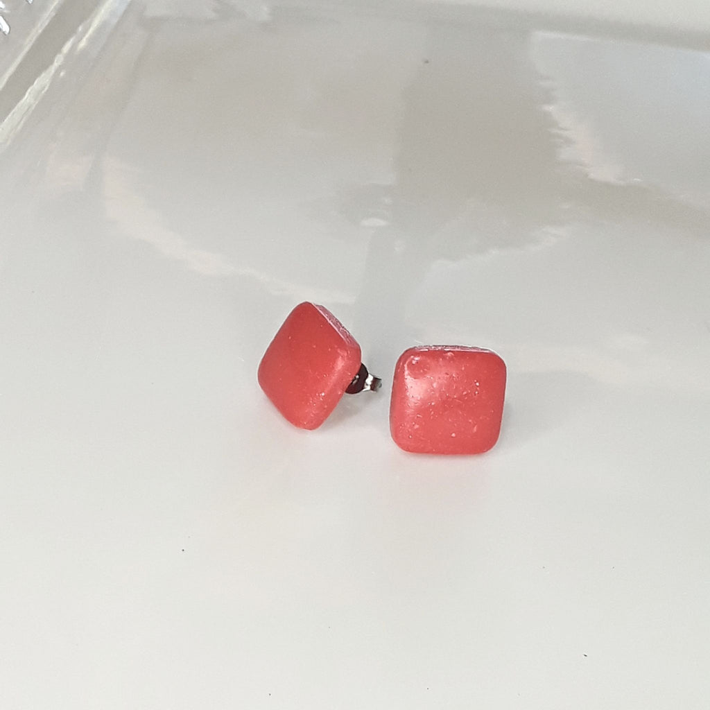 Handmade 14mm salmon pink square polymer clay stud earrings on white display tray