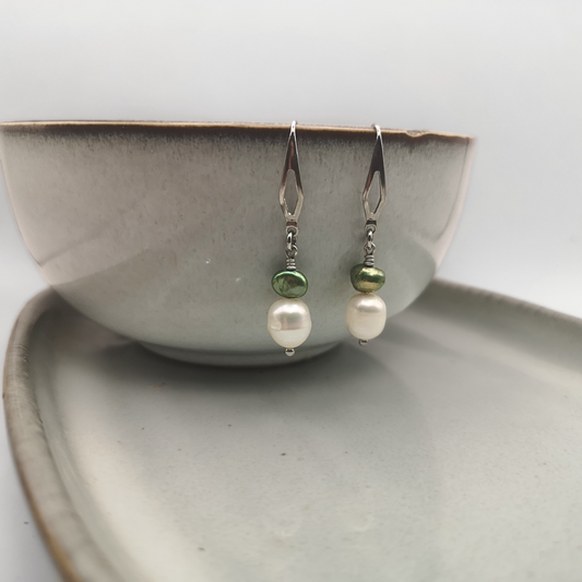 The Meadow Mist earrings pair the timeless elegance of a lustrous ±7 mm white freshwater pearl with the fresh, earthy charm of a small green potato-shaped freshwater pearl.