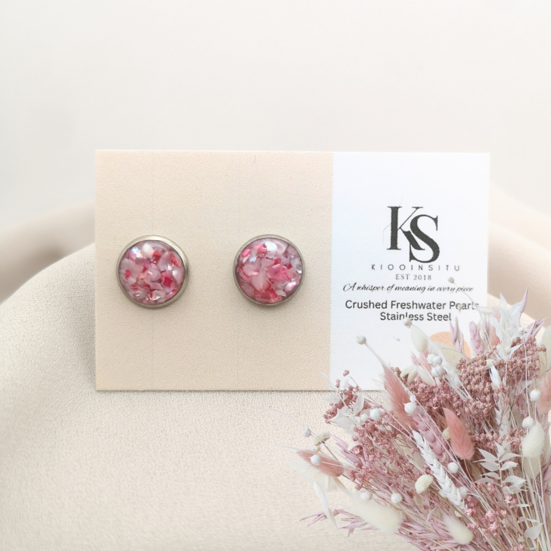 Delicately crushed freshwater pearls in pink hues, inlaid in 10 mm stainless steel bezels, sealed beneath a clear, glass-like resin that highlights their gentle shimmer.