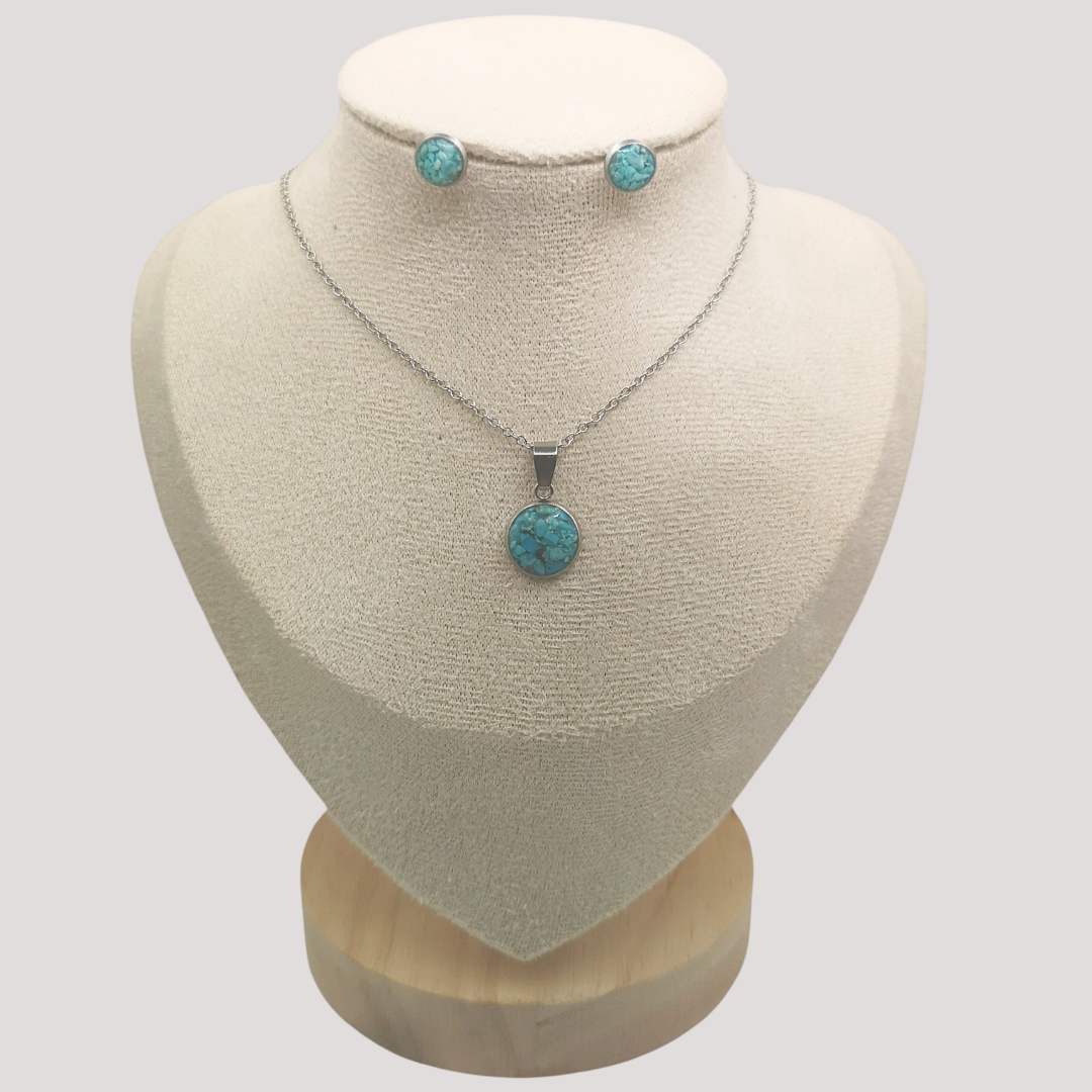 Jewelry set with turquoise pendant necklace and earrings on a mannequin bust.