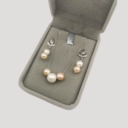 Pearl necklace with silver clasp in an open jewelry box on a light gray background