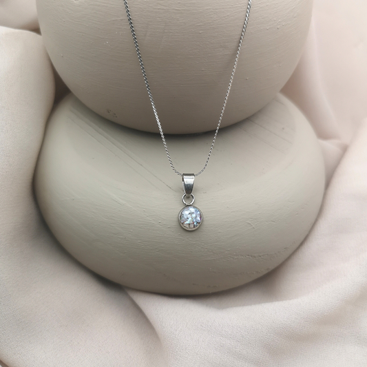 An 8 mm stainless-steel round pendant holds crushed freshwater pearls