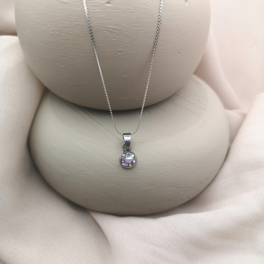 An 8 mm stainless-steel round pendant holds crushed freshwater pearls