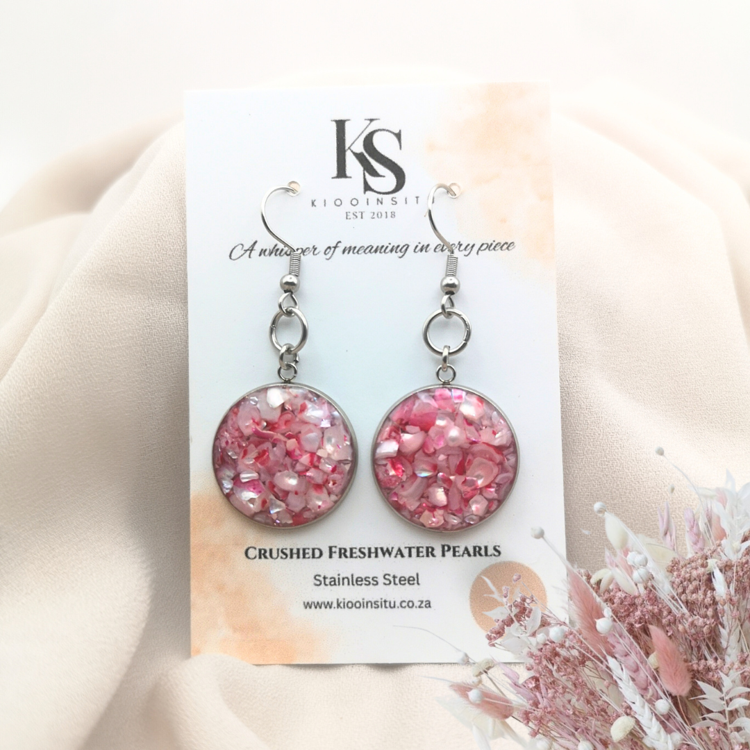 Pink crushed freshwater pearls glimmer within 20 mm stainless steel bezels, sealed beneath a clear, glass-like resin that enhances their natural radiance. 