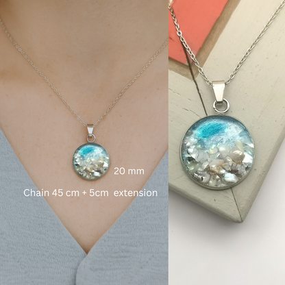 Necklace with a round pendant on a person and a plain background