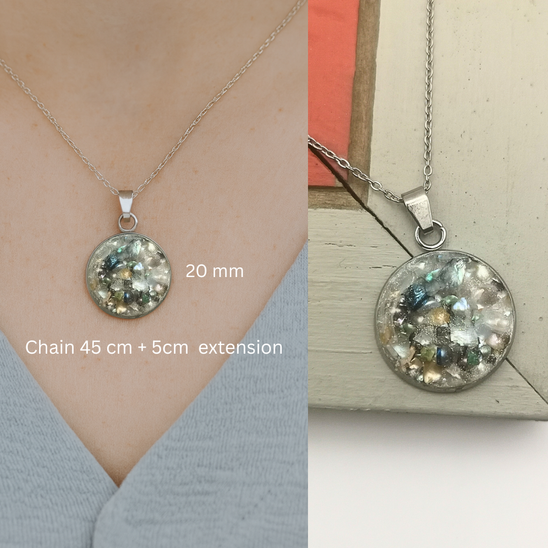 Silver necklace with a round pendant on a neutral background