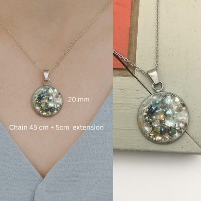 Silver necklace with a round pendant on a neutral background