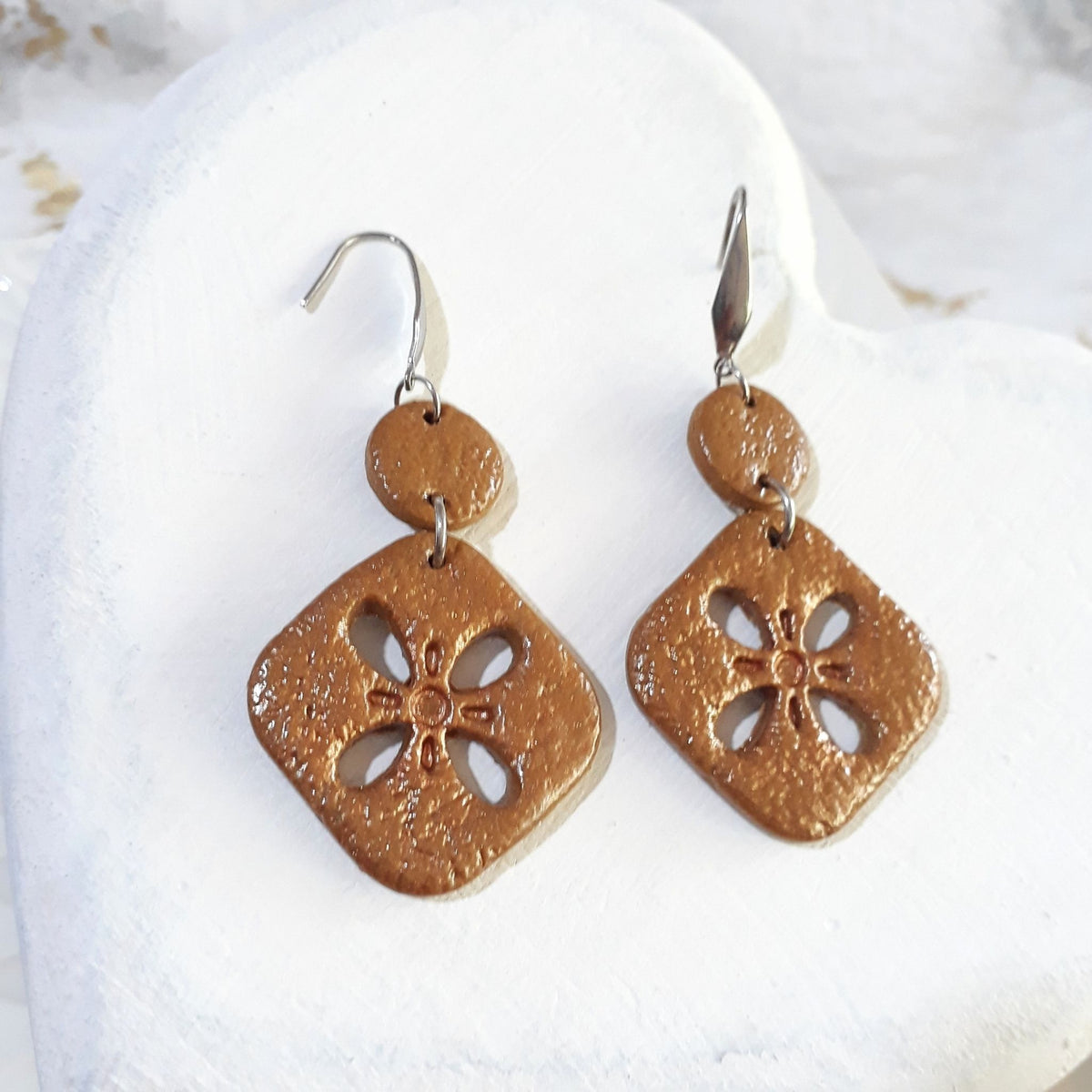 Golden caramel-brown textured polymer clay earrings with rounded diamond floral cutout drops, small round connectors and silver-tone elegant hooks.