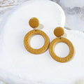 Golden mustard-yellow polymer clay earrings with smooth round stud tops and textured open-circle drops.