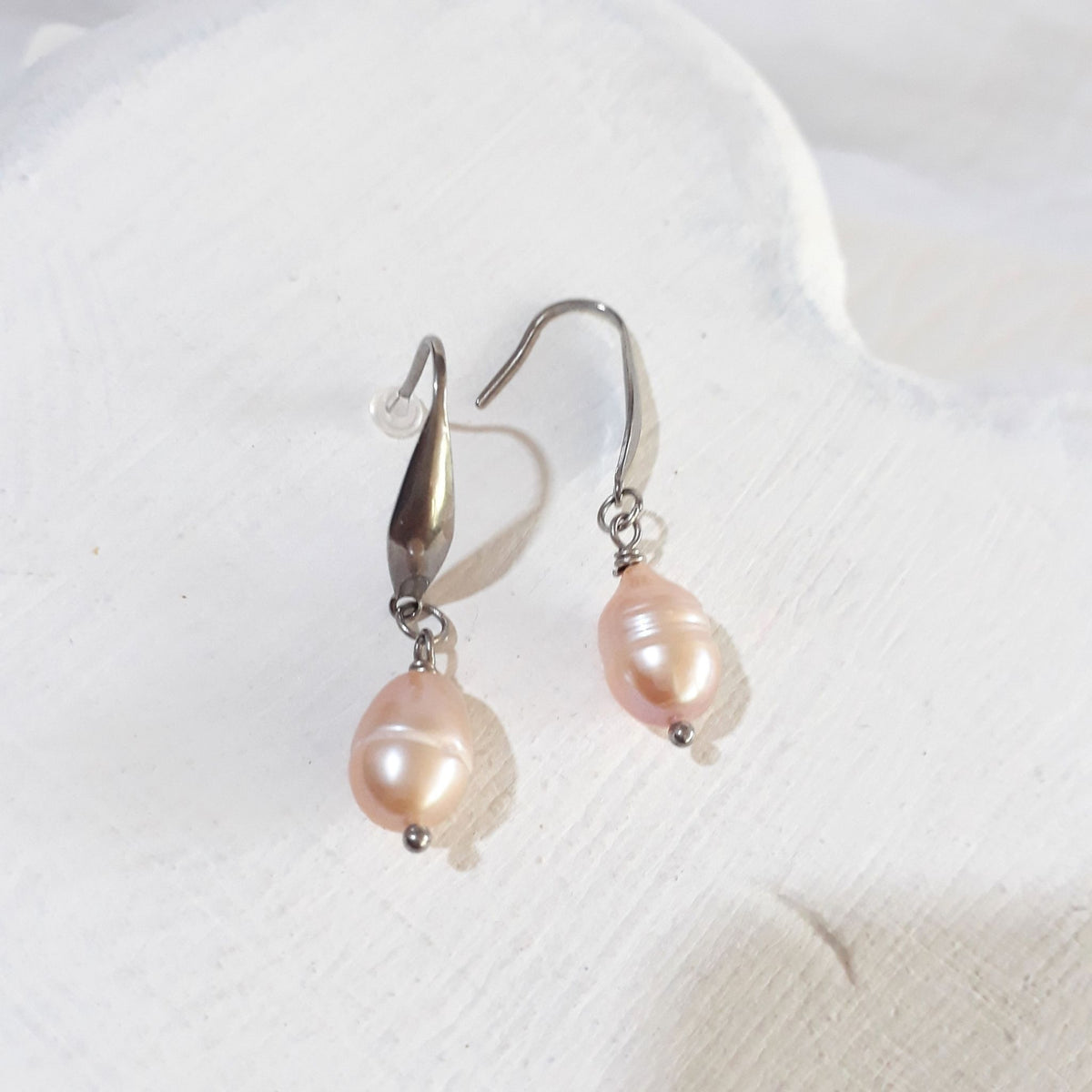 Peach-pink pear-shaped freshwater pearl drop earrings with silver-tone elegant ear hooks.