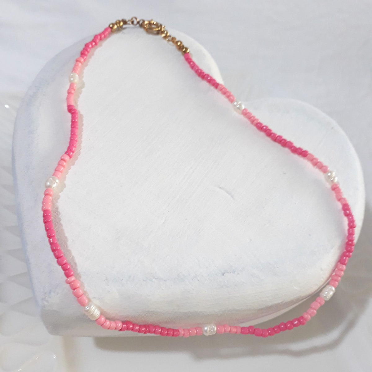 Pink Freshwater Pearl Beaded Necklace on a white wooden surface