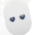 Heart-shaped blue earrings with gold accents on a white background