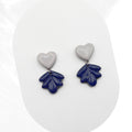 Heart-shaped earrings with leaf-like designs on a white background
