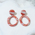 Pink, coral-pink and white patterned polymer clay earrings with round stud tops and open circular hoop drops.