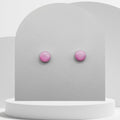 Pink stud earrings on a gray card with a white background