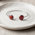 Handmade 304 stainless steel cuff bangle with 12mm bezels featuring natural crushed Red Coral sealed with clear resin.