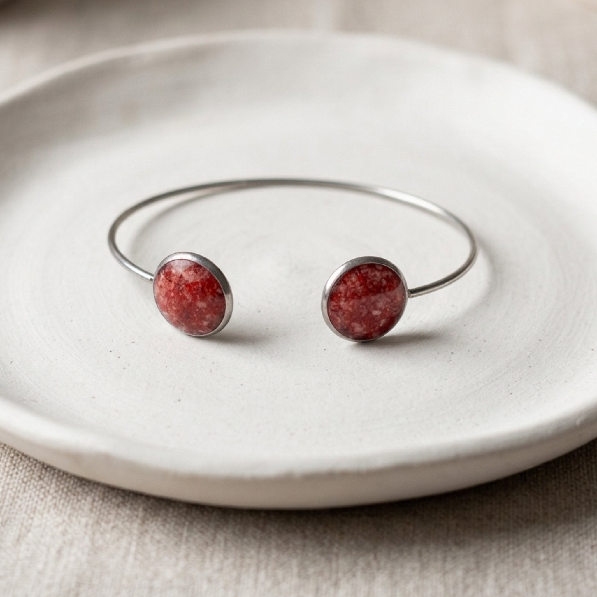 Handmade 304 stainless steel cuff bangle with 12mm bezels featuring natural crushed Red Coral sealed with clear resin.