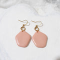 Salmon pink polymer clay dangle earrings with smooth rounded drops, gold-tone circle connectors and shepherd hooks.