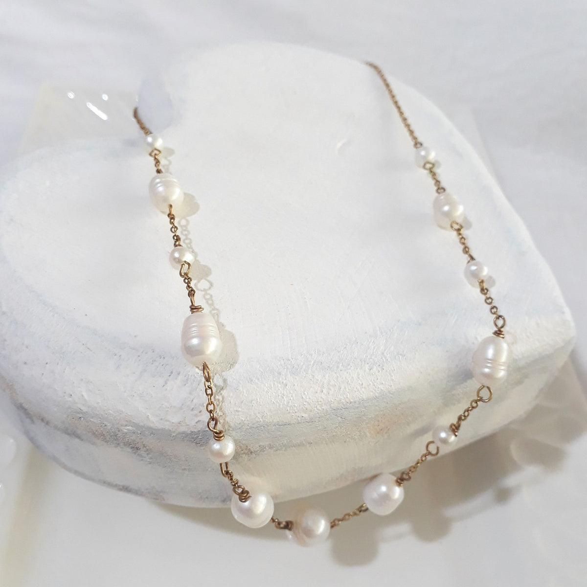 Handmade scattered freshwater pearl stainless-steel gold-plated necklace on a bust.