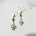 Silver freshwater pearl dangle earrings with grey ceramic hearts, small white bead accents and gold-tone shepherd hooks.