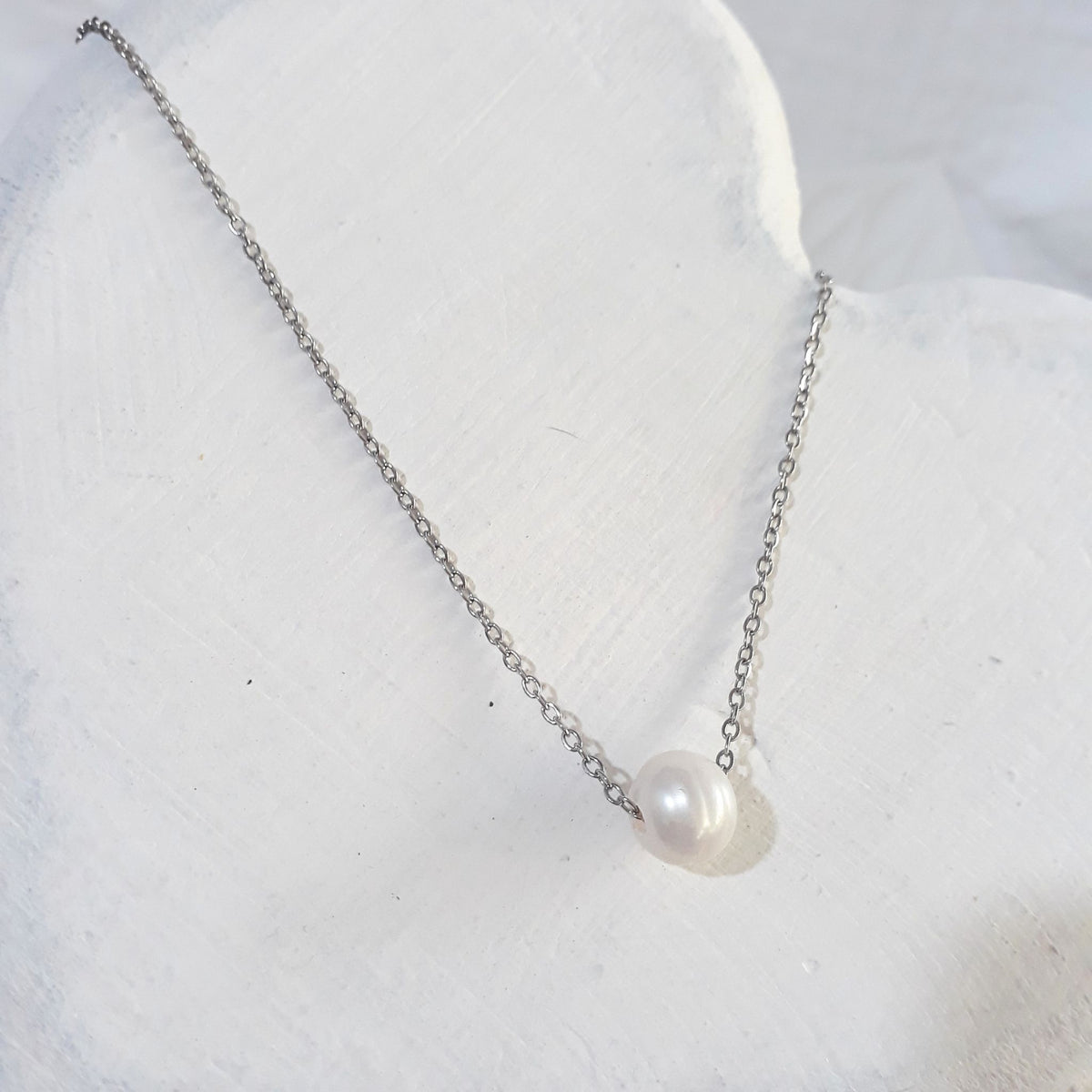 Single floating freshwater pearl on a stainless steel chain