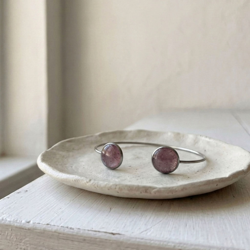Handcrafted with a sleek stainless steel open cuff design, this elegant bangle features two round bezels filled with natural crushed Pink Aura Quartz - Kiooinsitu
